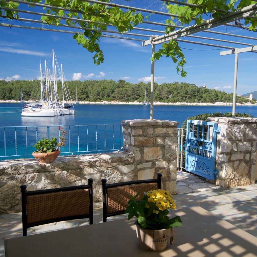Stone terrace with blue gate overlooking Fiskardo harbour