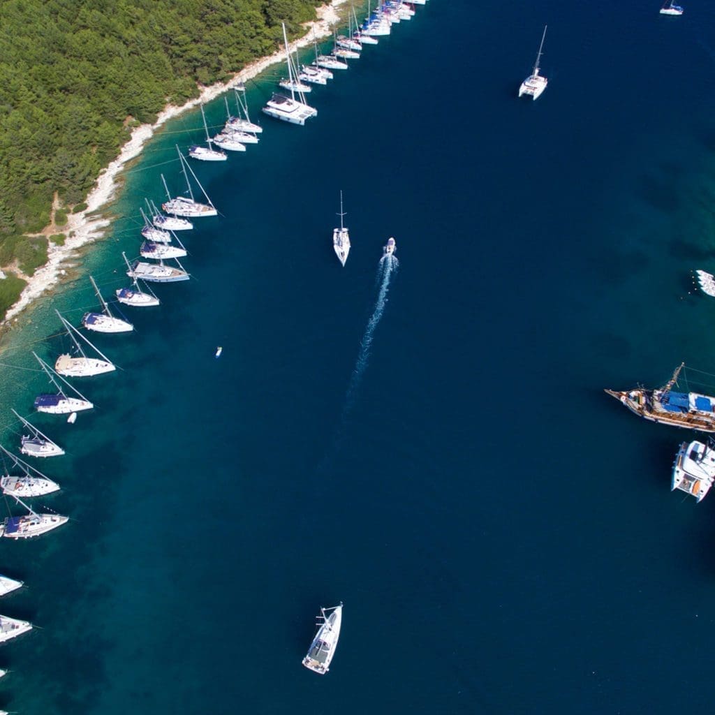 Aerial view of sailboats anchored in a blue bay near Fiskardo